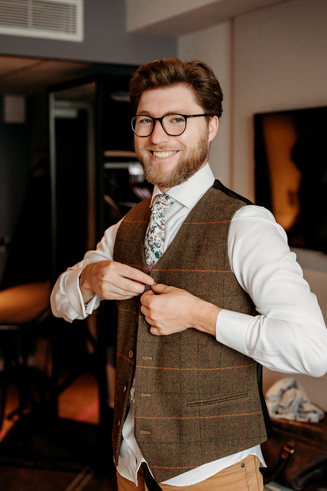 groom putting on his waist coat captured by a Hampshire wedding photographer