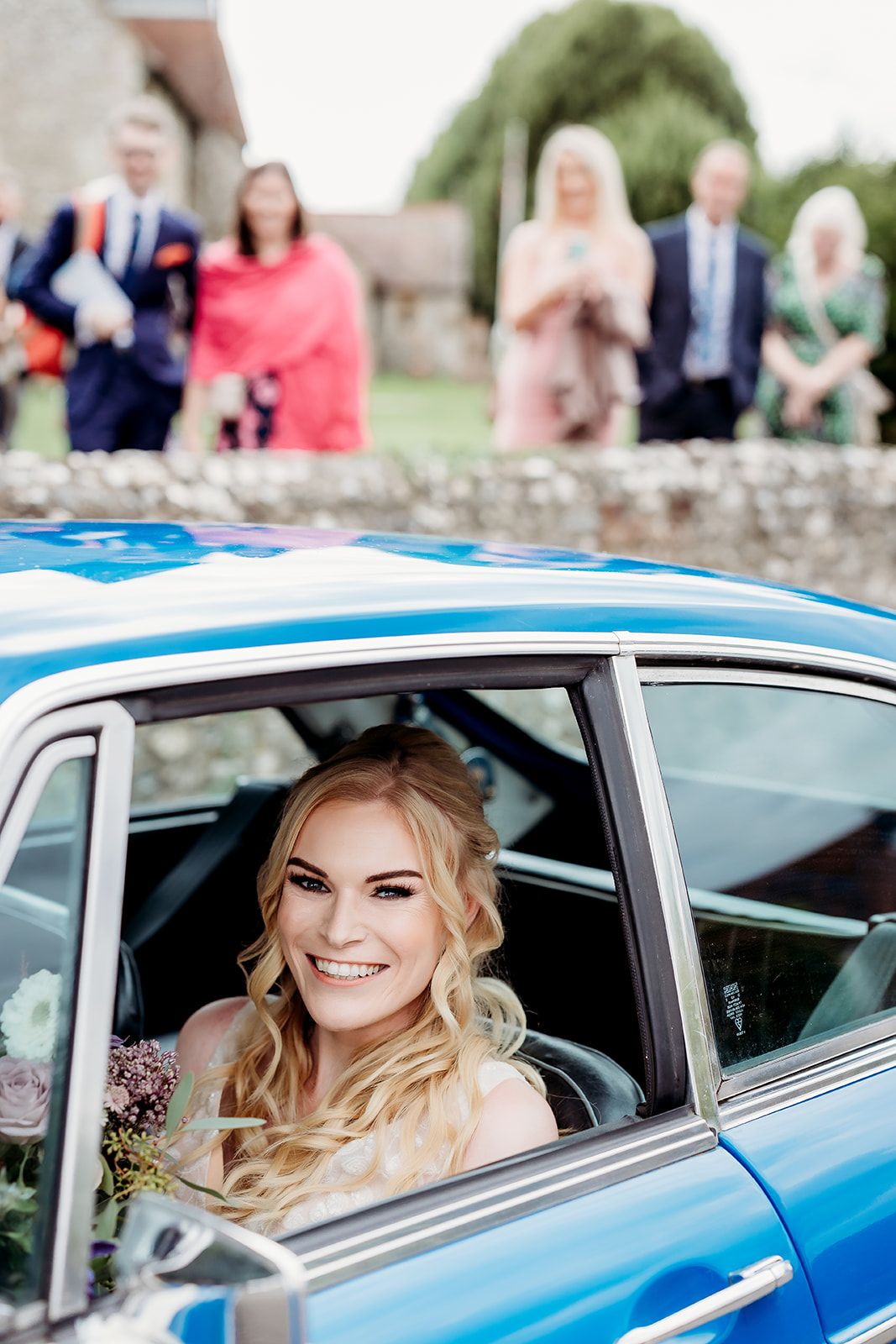 a bride smiling in her getaway car