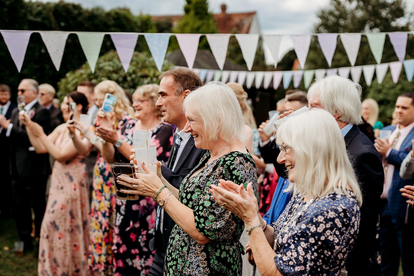 family and loved ones clapping after a speech captured by a Romsey wedding photographer
